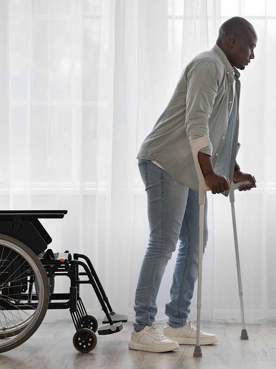 Man rehabilitating on crutches 12 months after badly broken leg